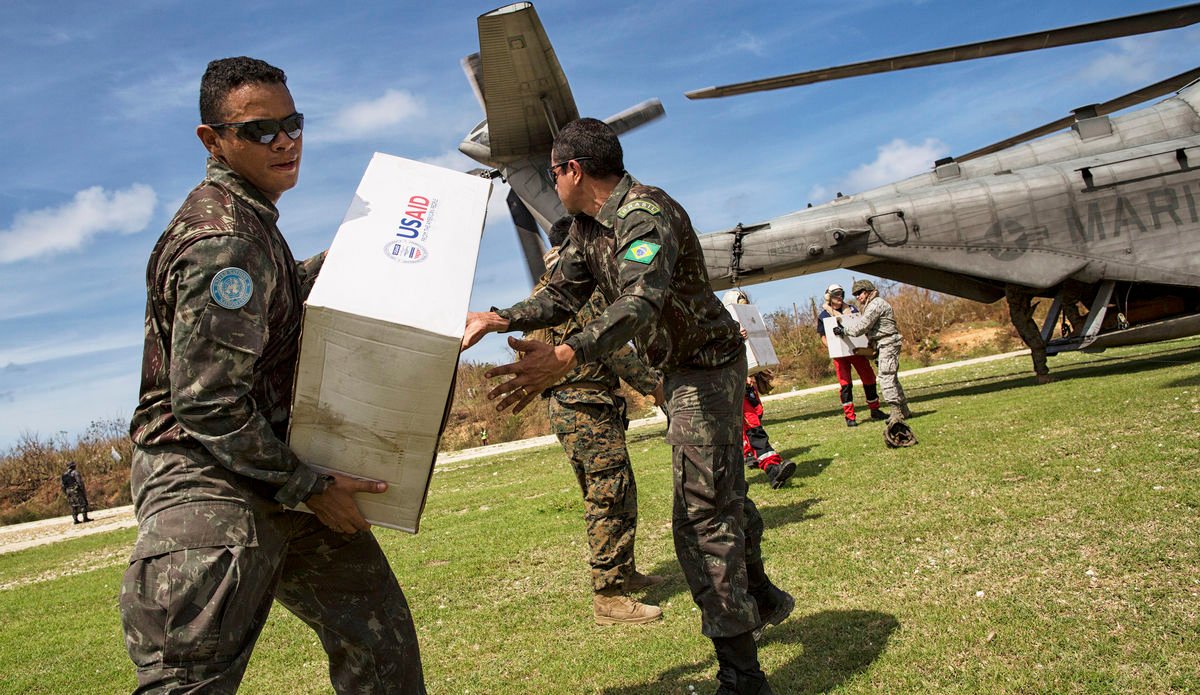 Brazilian peacekeepers from the United Nations Mission in Haiti (MINUSTAH) help unload a US military helicopter of supplies. 