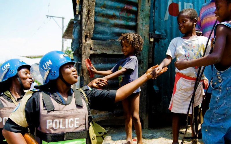 UN Photo/Marco Dormino Nigerian FPU Officers speak with children as they patrol the slum of Martissant